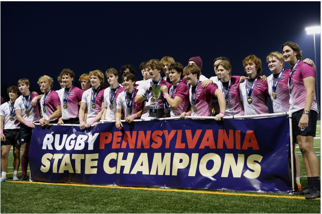 Triumphant team: The boys’ rugby team poses for a photo behind the state championship banner. It defeated Hempfield High School’s rugby team and became the state champion on Nov. 5.
